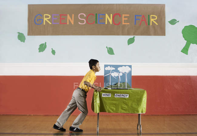 Мальчик толкает стол на Science Fair — стоковое фото