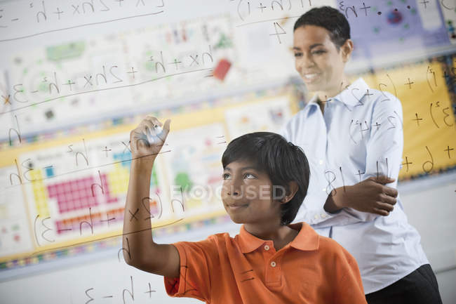 Estudiante escribir fórmula y ecuaciones - foto de stock