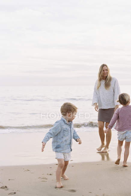 Женщина играет с сыном и дочерью — стоковое фото