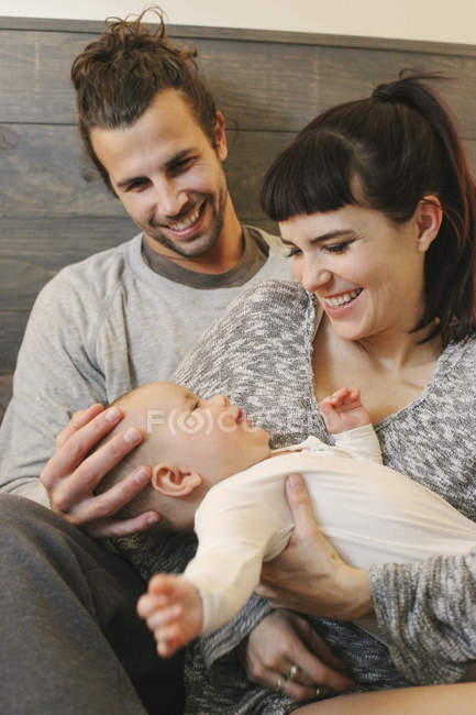 Madre, padre y bebé jugando - foto de stock