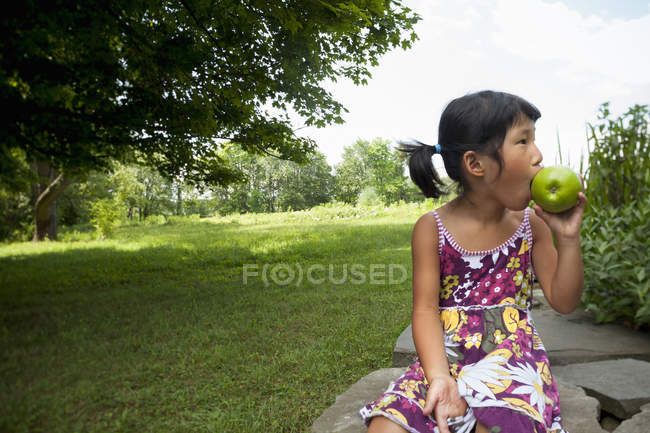 Child chewing green apple — Stock Photo