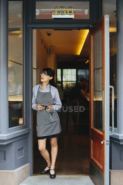 Официантка, стоящая возле городского ресторана — стоковое фото