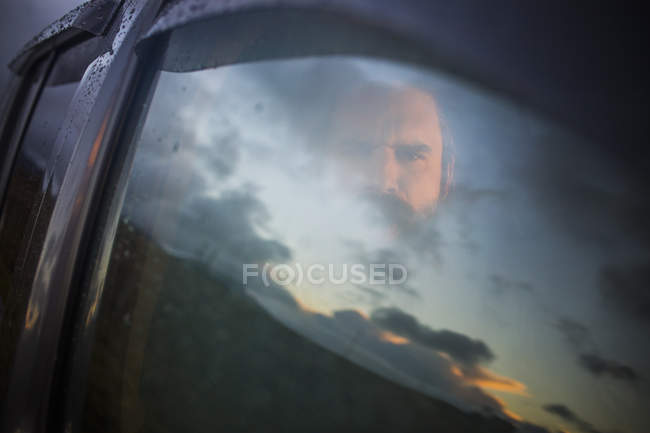 Мужчина, сидящий в машине и выглядывающий
. — стоковое фото