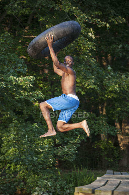 Junge springt vom Steg ins Wasser — Stockfoto
