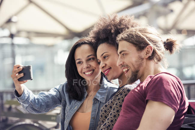 Man and women taking selfies in city park — Stock Photo