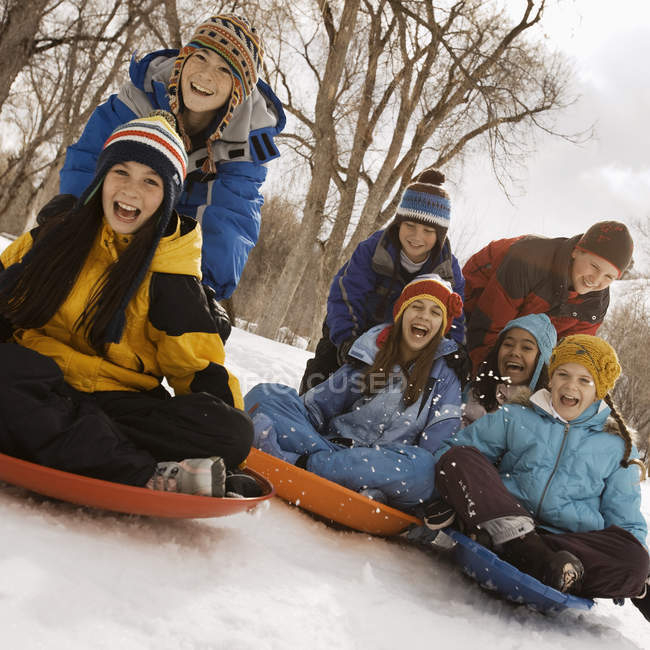 Дети катаются на санях по снегу . — стоковое фото