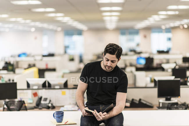 Homme assis sur un bureau — Photo de stock