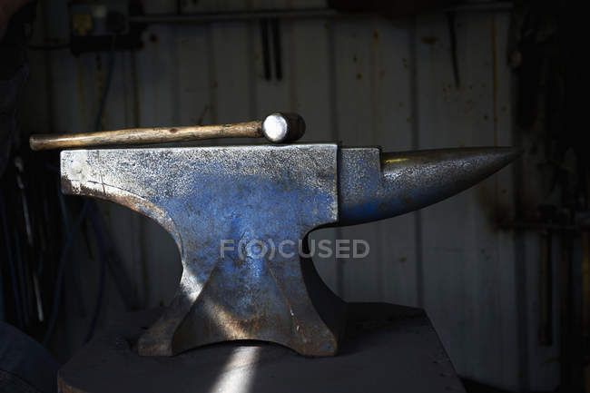 Hammer lying on an iron anvil — Stock Photo