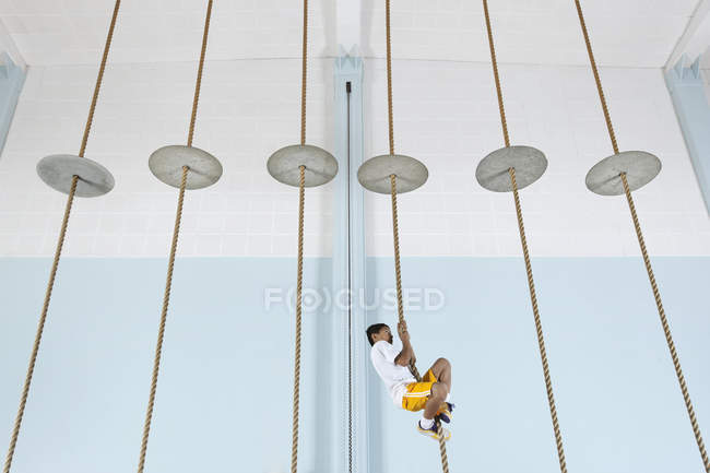 Boy climbing up a rope — Stock Photo