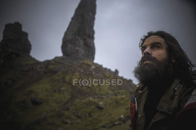 Чоловік стоїть з фоном гірських скель — стокове фото