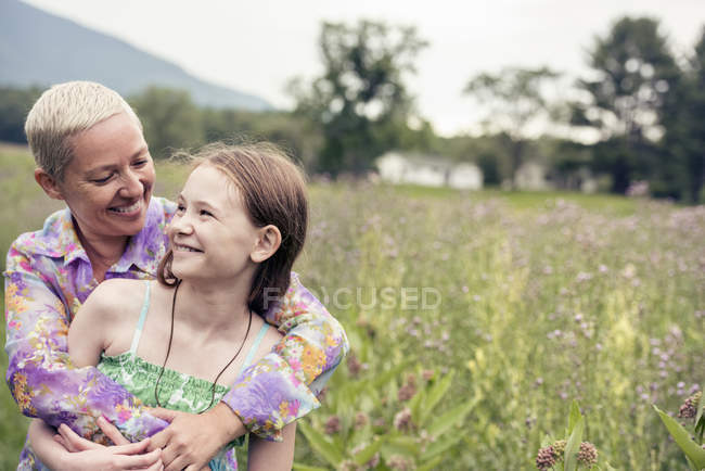 Mujer y niña en un prado de flores silvestres - foto de stock