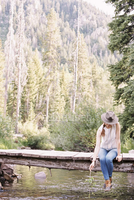 Frau sitzt auf einer Holzbrücke — Stockfoto