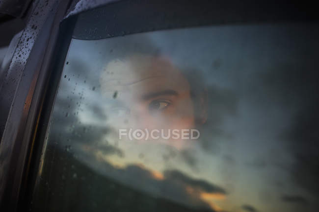 Uomo seduto in una macchina guardando fuori . — Foto stock