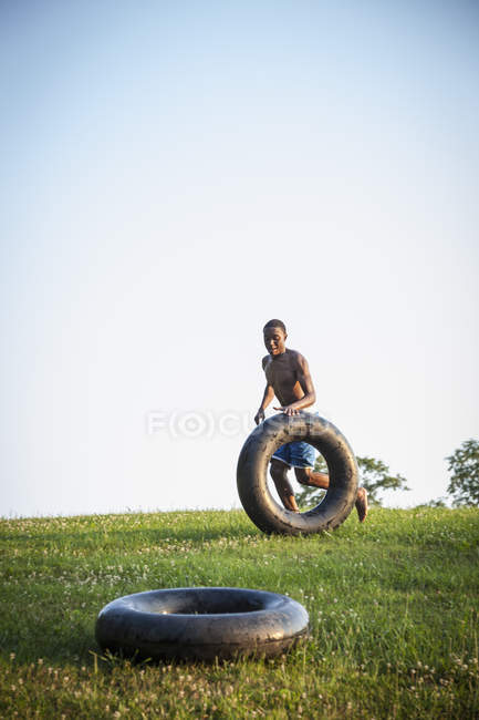 Boy rolling a swim float — Stock Photo