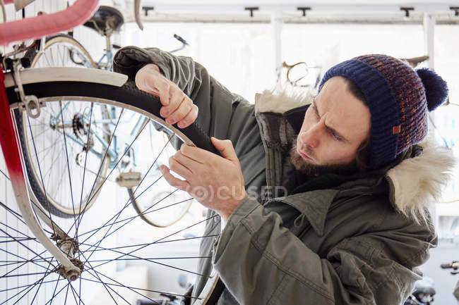 Молодой человек, работающий в велосипедном магазине — стоковое фото
