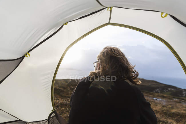 Человек, сидящий в палатке — стоковое фото
