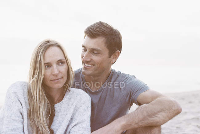 Couple sitting close on a beach — Stock Photo
