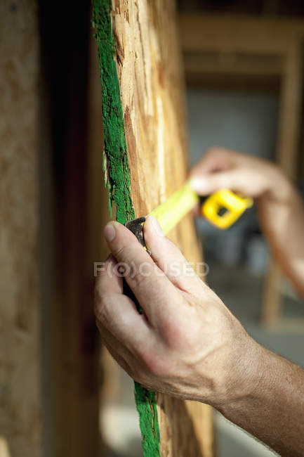 Homem que mede prancha de madeira — Fotografia de Stock