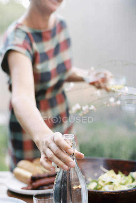 Femme tenant deux verres et bouteille — Photo de stock