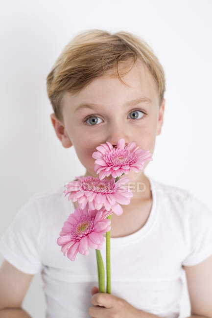 Young boy holding a bunch of flowers. — Stock Photo