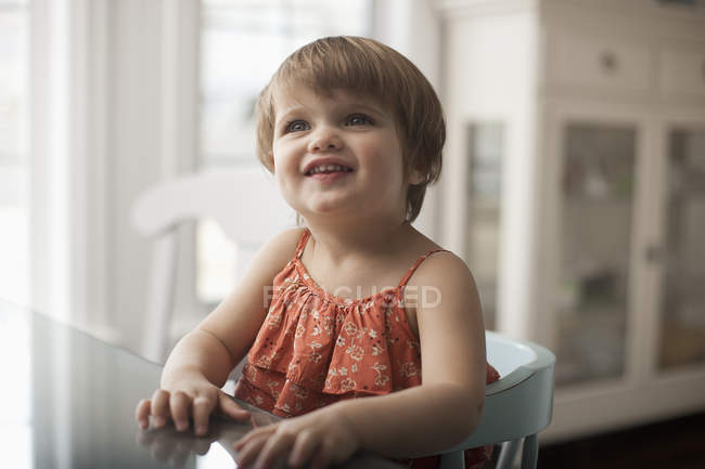 Girl sitting at a table — Stock Photo
