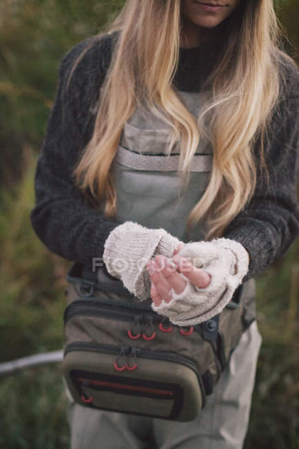 Mujer que se pone guantes sin dedos de lana . - foto de stock