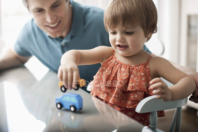 Мужчина и ребенок играют с игрушечными автомобилями . — стоковое фото