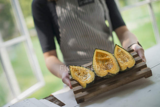 Person holding a tray grilled pumpkin. — Stock Photo