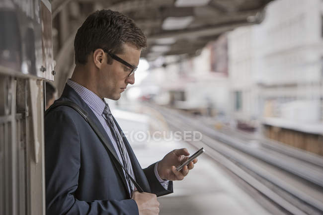 Businessman on a station platform — Stock Photo