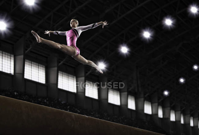 Mujer gimnasta realizar en la viga - foto de stock