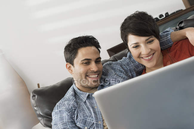 Paar blickt auf den Bildschirm eines Laptops. — Stockfoto