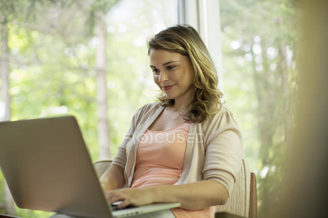 Femme assise en utilisant un ordinateur portable — Photo de stock