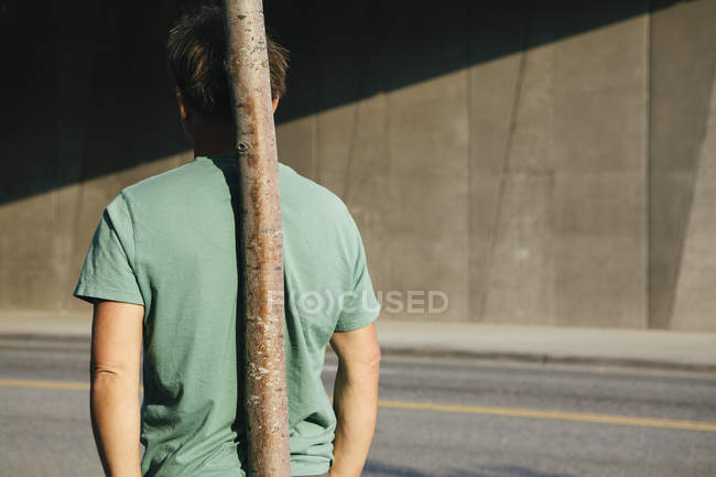 Man leaning against small tree — Stock Photo