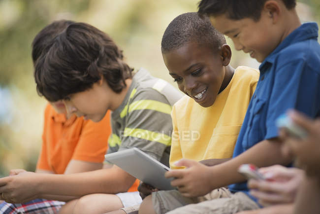 Crianças usando tablets e jogos de mão . — Fotografia de Stock
