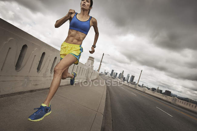 Женщина бежит по городской дороге — стоковое фото