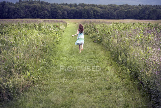 Fille courir à travers une prairie — Photo de stock