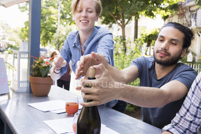 Young man and woman outdoors at a cafe — Stock Photo