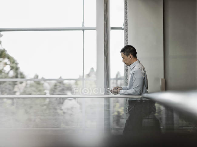 Man standing by a large window — Stock Photo