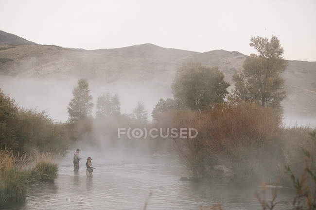 Couple pêche à la mouche dans une rivière . — Photo de stock