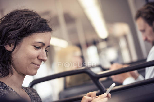 Frau im Bus schaut auf ihr Handy — Stockfoto