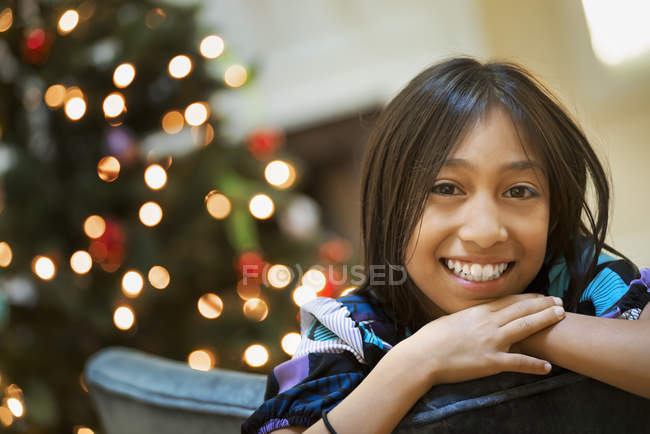 Girl smiling and leaning over chair back — Stock Photo