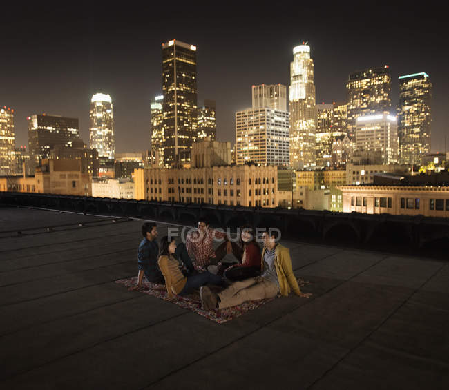 Amigos reunidos en una terraza en la azotea - foto de stock