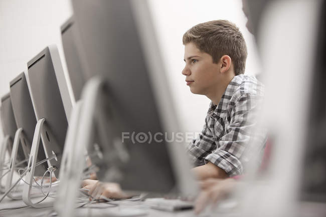Joven sentado trabajando en una terminal - foto de stock