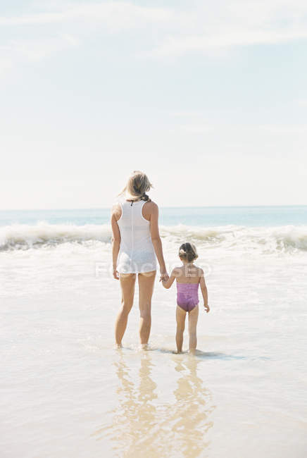 Женщина с дочерью на песчаном пляже . — стоковое фото