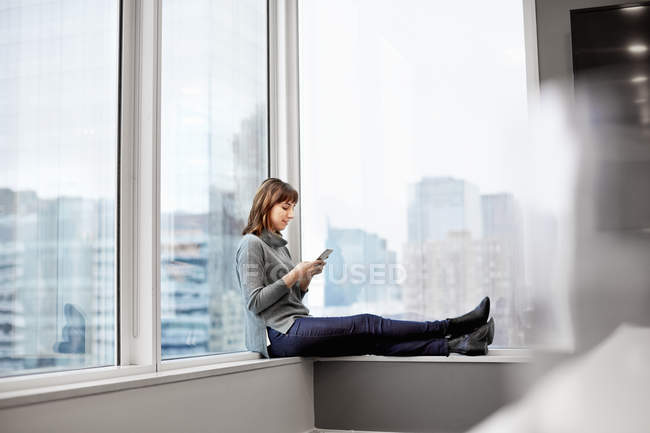 Frau hält Smartphone in der Hand — Stockfoto