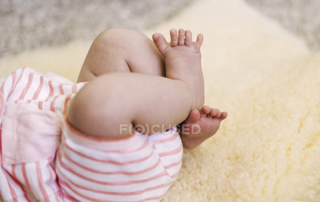 Baby liegt auf einem Schaffellteppich — Stockfoto