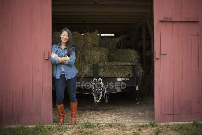 Mujer en una granja tradicional en el campo - foto de stock