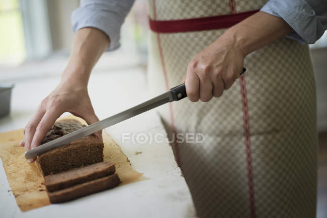 Frau schneidet Schokoladenkuchen. — Stockfoto