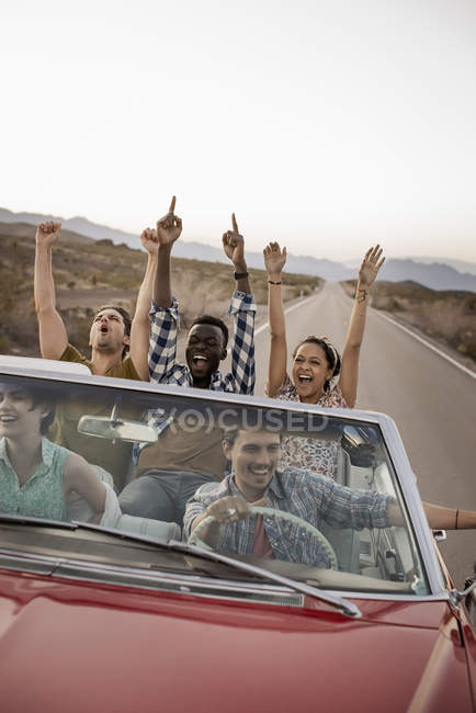 Amigos en coche convertible en un viaje por carretera . - foto de stock