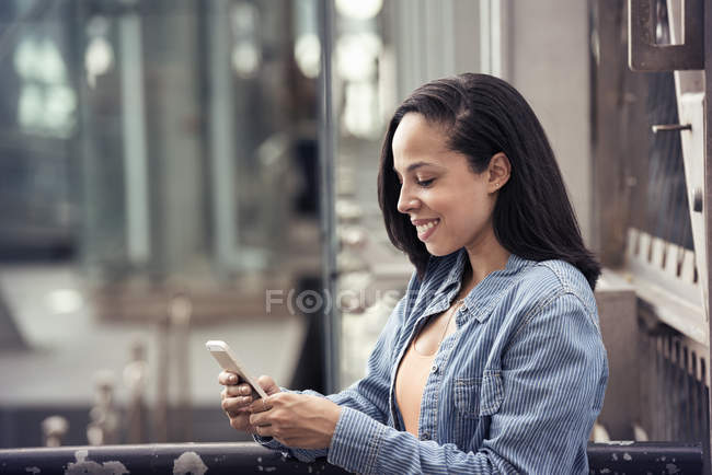 Femme vérifiant son téléphone portable — Photo de stock